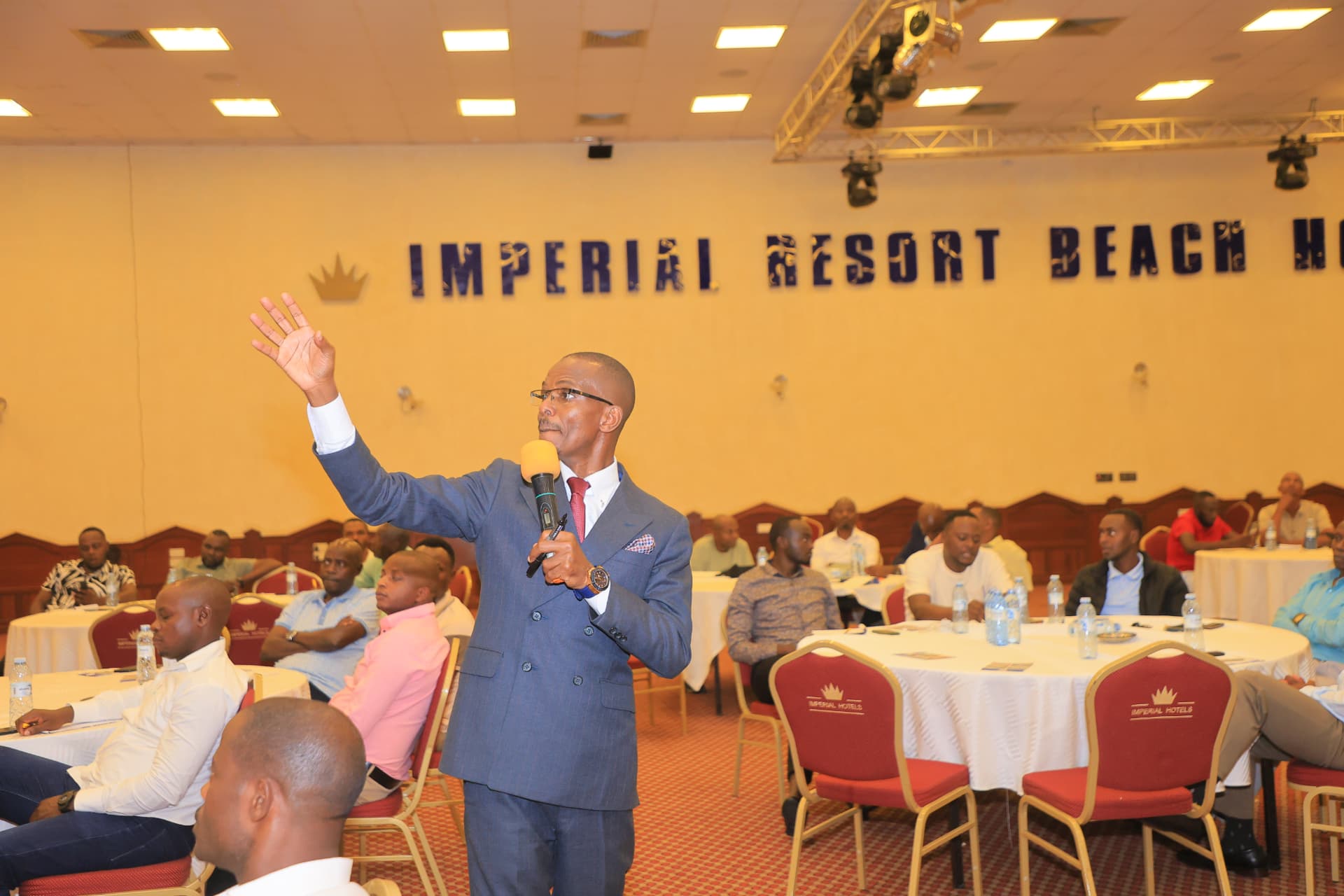 Newton Buteraba addressing a conference hall at Imperial Resort Beach Hotel